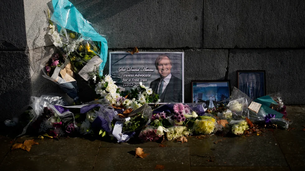 Blommor utanför parlamentet i London efter mordet på David Amess i fjol. Arkivbild.