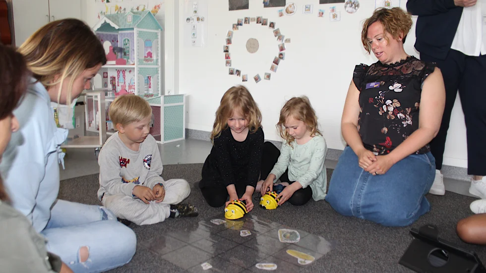 Förskolebarnen Pella Karlsson, systrarna Leia och Jolie Lundgren och deras pedagog Anneli Borell visar de gästande kraotiska och italienska förskollärarna hur man använder roboten. 