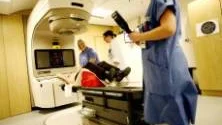 Första besöket hos strålkanonen på Karolinska. Onkologsjuksköterskan May-Louise Attebring, till vänster och sjukhusfysikern Kristin Karlsson ser till så att jag ligger exakt rätt på britsen.