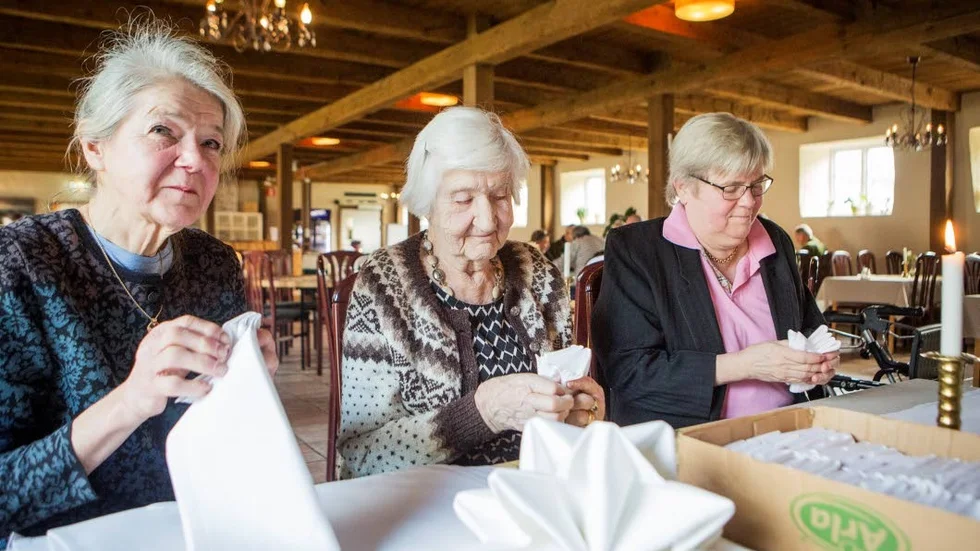 Mamma (i mitten) och systrarna passar på att vika servetter.