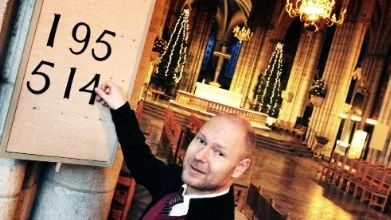 Domkyrkovaktmästaren Rickard Pettersson sätter upp psalmnummer inför nyårsbönen.