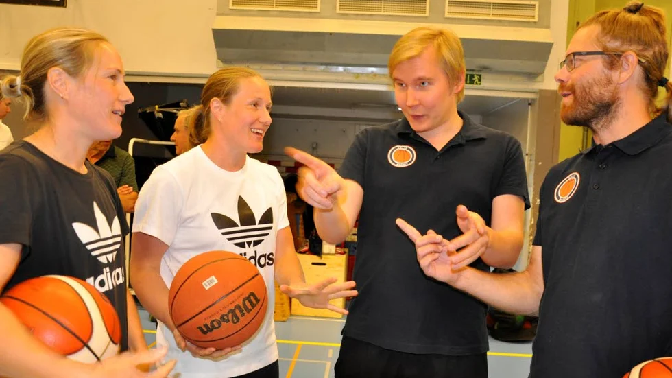 Frida och Elin Eldebrink samtalar med tränarna Jari Leskinen och Mattias Johansson.