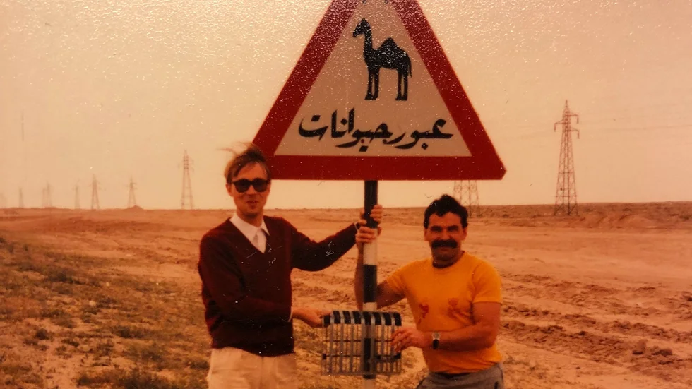 Magnus Åkerman och hotellets walesiske Recreation Manager David Greedy poserar med en ”varning för kamel”-skylt i Kuwait. 
