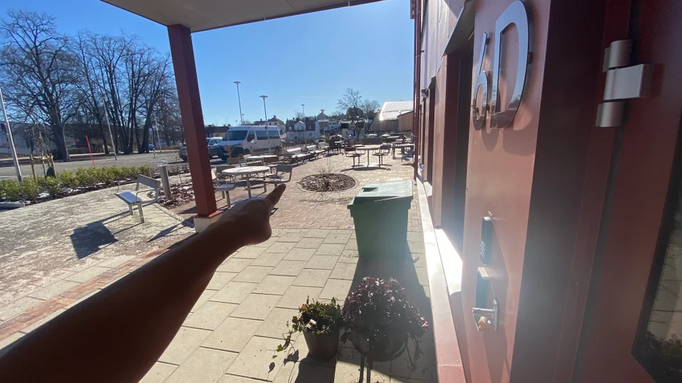 Personalen på äldreboendet behöver gå genom långa korridorer och sedan utomhus för att slänga sopor. Ibland tar de vägen genom huvudentrén som på bilden. Annars går det också att gå inomhus en bit i den riktning som personen på bilden pekar åt.