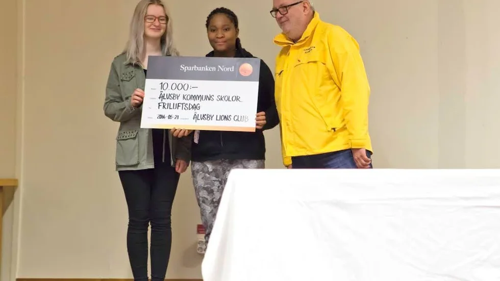 Gåva. Från vänster Sabina Johansson, Ruth Mbakwe och presidenten Sterling Nilsson.