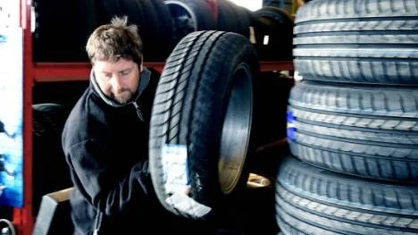 Däckias platschef Magnus Nordmark plockar fram ett av de cirka 6000 däck som företagets personal byter varje säsong.