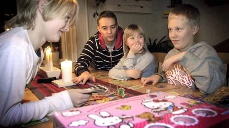 Hannes Forslund utmanar sin kamrat Eric Petit i en bokstavlek. Rickard Forslund och Henny Forslund tittar på.