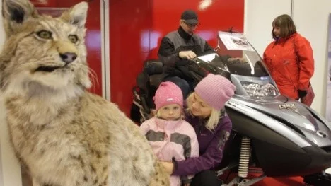 Lynx, betyder lodjur, och självklart måste en riktig sådan finnas med i ett show room för Lynx-skotrar. I mitten sitter Lilly och Åsa Sandström.