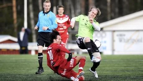 TUFFA TAG. Piteås Alexander Lindahl (röd) sätter in en tackling på Assis Pär Lygren (grön).