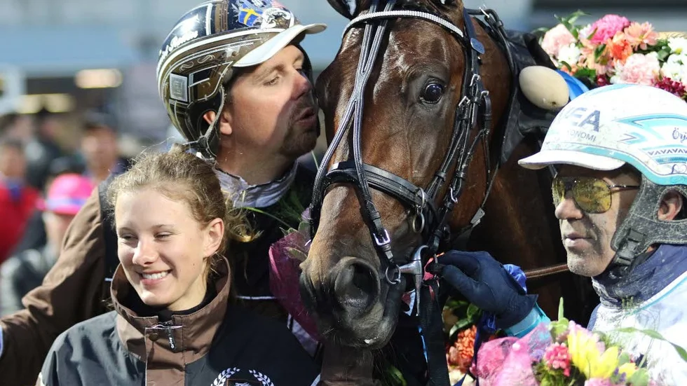 Propulsion får segerkyss av tränaren Daniel Redén. Kusken Örjan Kihlström står med blommer till höger.