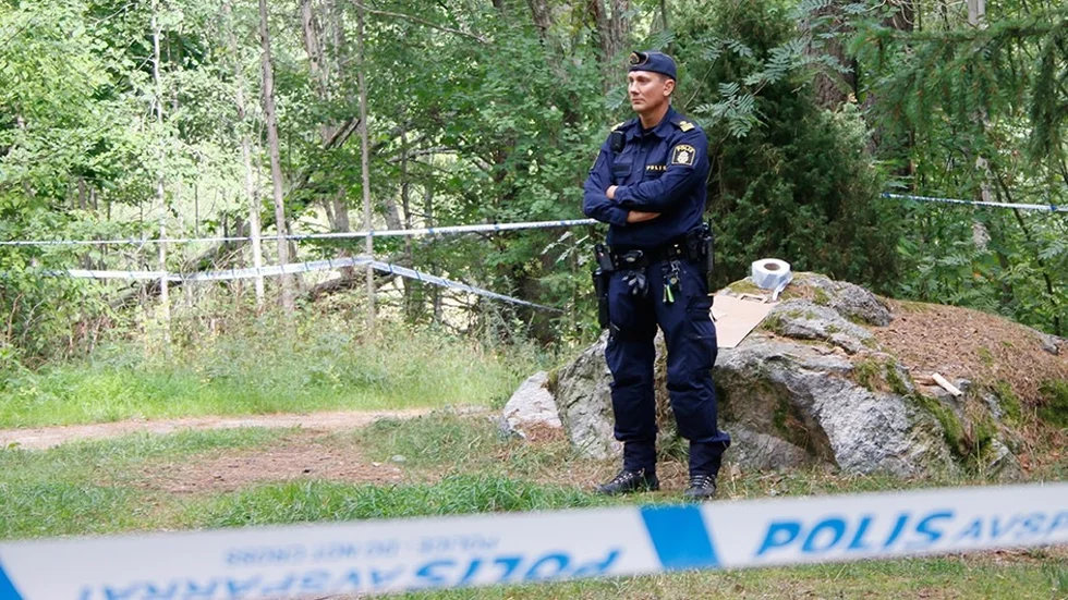 En polisman bevakar avspärrningarna i Årbyskogen (arkivbild).