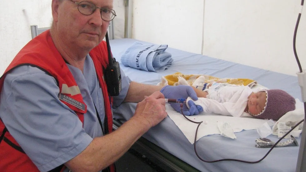 Barnsjuksköterskan och Eskilstunabon Christer Östmark i färd med att ge blod till en liten patient på fältsjukhuset i Bangladesh.