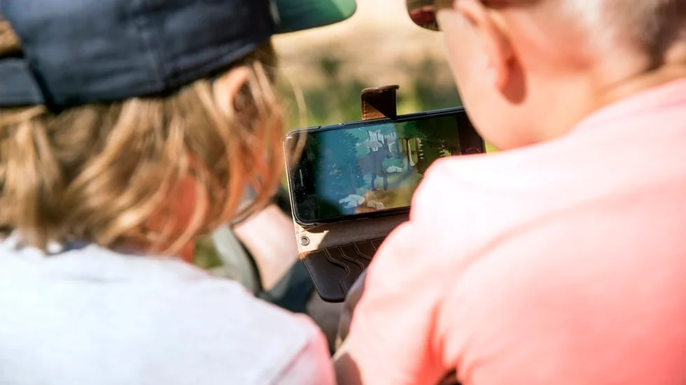 Appen Skogsmulle och naturboken lockar barn ut i naturen. Med hjälp av mobilen får barnen leta upp växter och djur att fotografera bland annat.