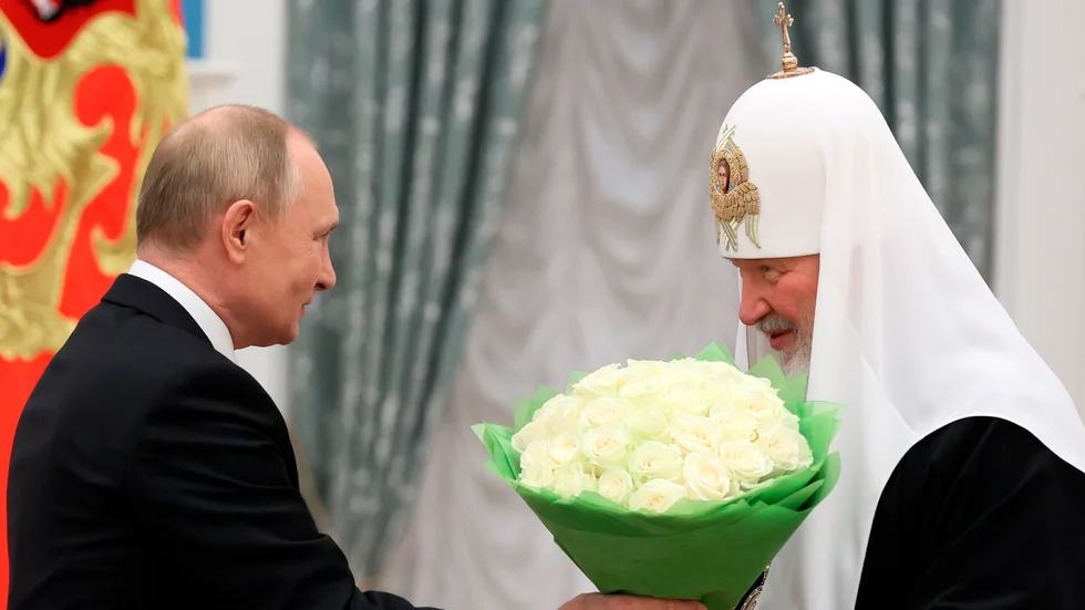 Vladimir Putin förärar den rysk-ortodoxe patriarken med en bukett. Kirill vill att ryssar visar en helt enad front bakom Putins krigslinje. Arkivbild.