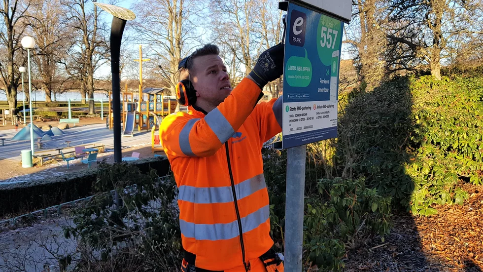 Tobias Johansson från Motala kommun fixade med skyltarna under onsdagen. Nu finns bara en parkeringsapp kvar på de kommunala parkeringarna. 