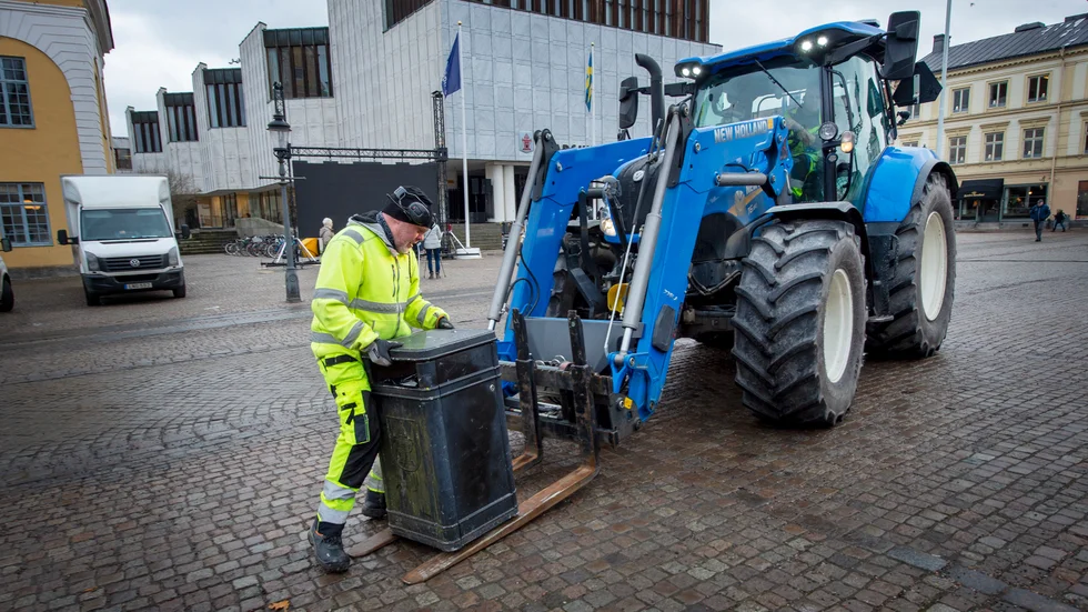 Villy Elg lastar soptunnor på Stora torget.