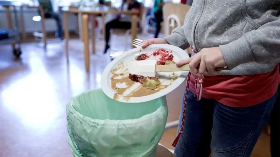 Mat som blir över skrapas ner i hinken. Skillnaden mot tidigare är att den ska vägas när alla ätit klart.