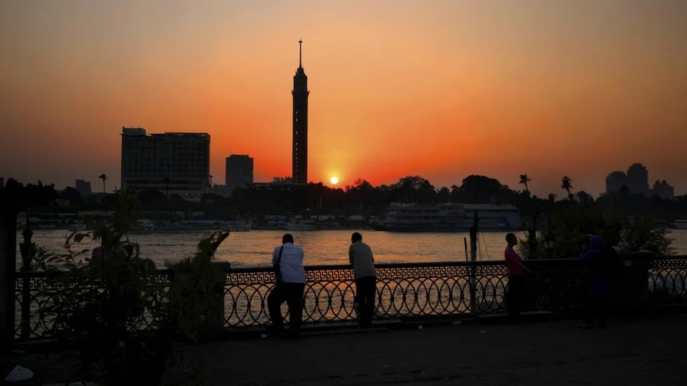 FILE - In this Wednesday, Aug. 5, 2015 file photo, Egyptian men enjoy the sun setting over the Nile River in Cairo, Egypt. (AP Photo/Hassan Ammar, File)
