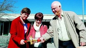 Nyhemsskolans rektor Marianne Antonson, Gun Axelsson, ordförande i det kommunala fastighetsbolaget Vallonbygden och Peter Fransson (s), ordförande i humanistiska nämnden, slår i den första symboliska spiken för tillbyggnaden av Nyhemsskolan. Foto: Johan Gustafsson