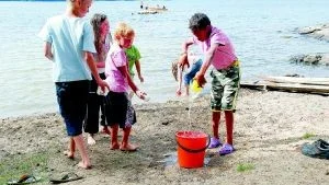 Under patrullkampen på sommarlägret gäller det att snabbt fylla en tiolitershink med vatten. Samuel Rising, 11 år från Sonstorp, Beatrice Andersson, 10 år från Närkesberg, Edvin Abrahamsson, 9 år från Hällestad, tittar på när Michel Pinna, 11 år från Hällestad, häller i det sista vattnet i hinken. Annie Östlund, 9 år från Hult, hämtar mer vatten för att vara på den säkra sidan.  Foto: Johan Gustafsson
