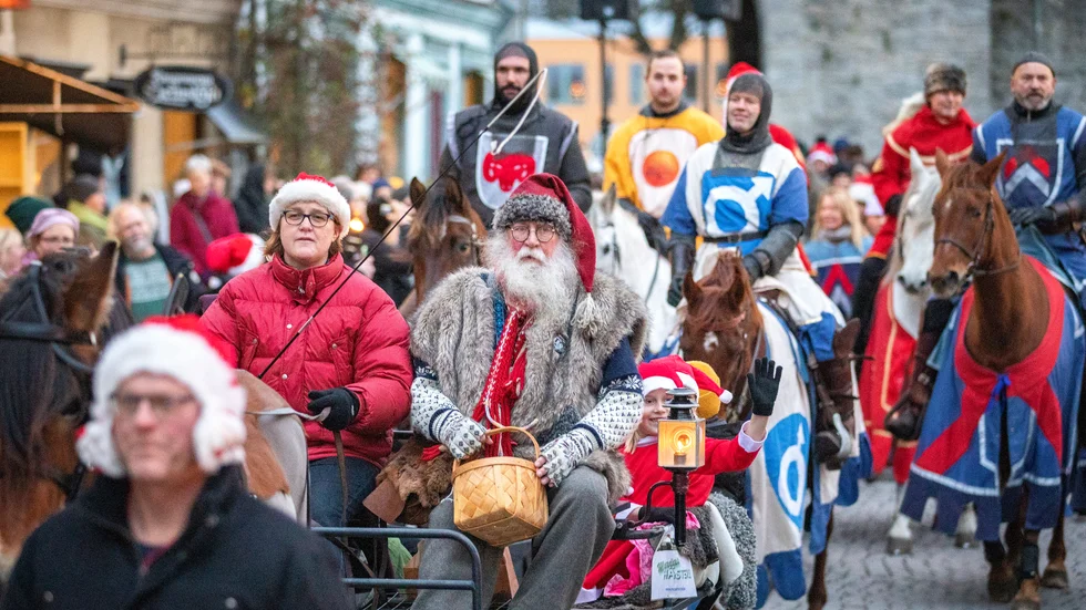 Tomten och några nissar åkte häst och vagn framför ridande riddare.
