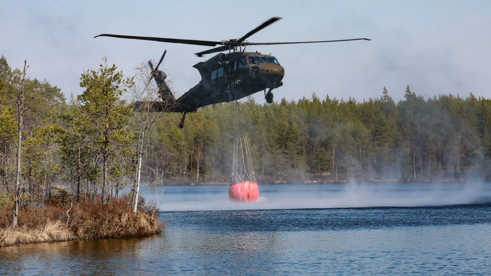 Helikopter har kallats ut för att vattenbomba gräsbränderna vid järnvägen, söder om Harrå. Bilden är tagen vid ett annat tillfälle.