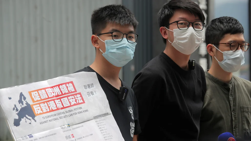 Demokratiaktivisterna Joshua Wong (till vänster), Sunny Cheung (mitten) och Nathan Law med ett plakat som uppmanar europeiska ledare att ta strid mot Kinas planer på att beskära Hongkongs autonomi genom en ny nationell säkerhetslag.