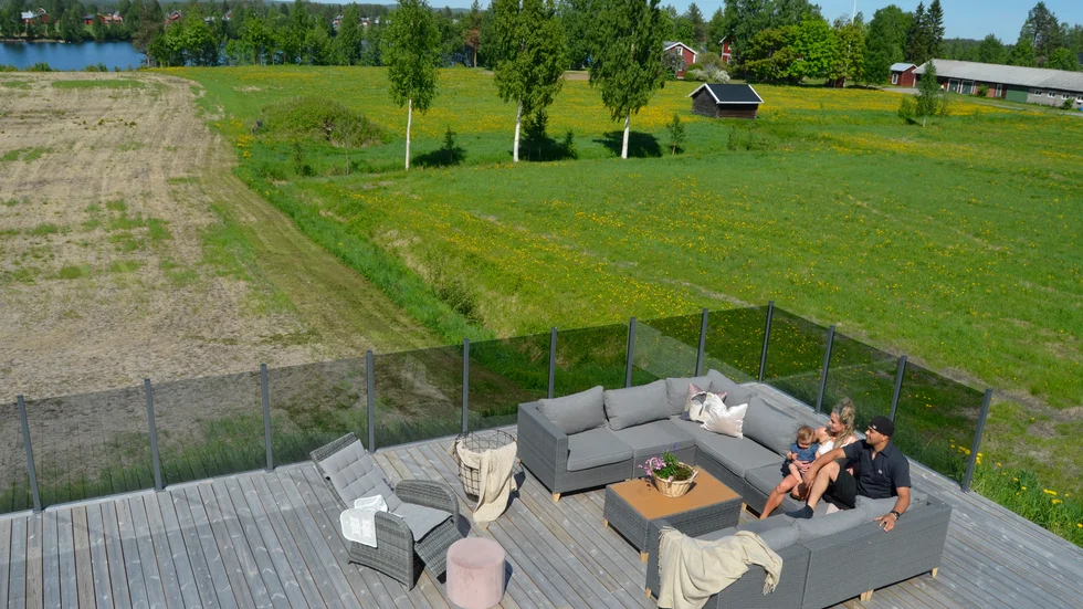 Sandra Lindgren och Mohanned Jawda med dottern Estelle. Paret byggde en 325 kvadratmeter stort trädäck runt hela huset. De tonade glasräckena gör att de får ut det mesta av den idylliska utsikten. 