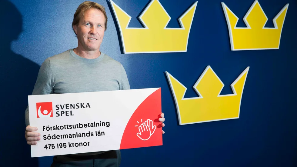 Hockeyns förbundskapten Johan garpenlöv visar upp checken till Södermanlands ungdomsidrott.