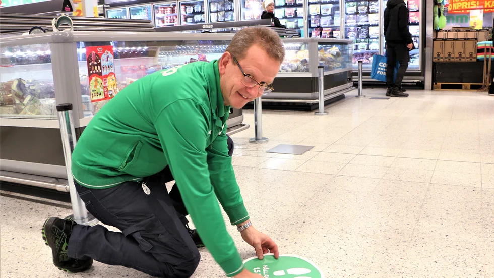 Janne Lindström, stormarknadschef på Stora Coop i Piteå, satte upp fler golvdekalar under onsdagen. De uppmanar kunderna att hålla avstånd.