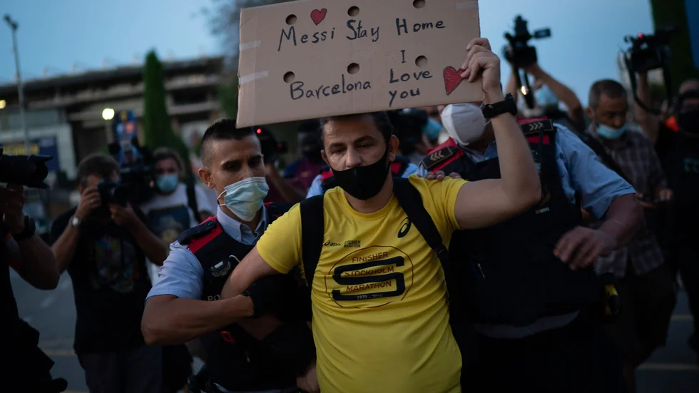 Polis för bort en Barçasupporter i samband med protesterna vid Camp Nou på onsdagen.