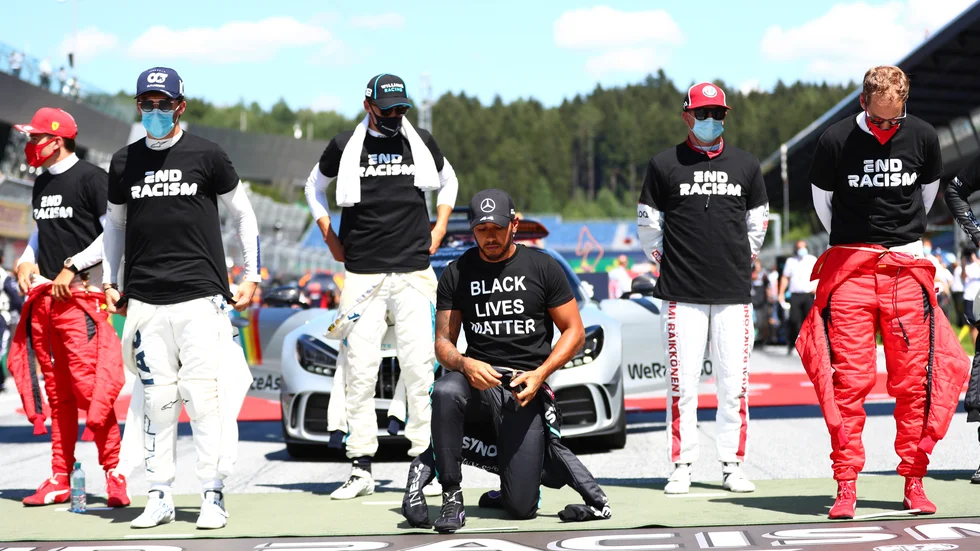 Lewis Hamilton knäböjer inför F1-premiären i Österrike.