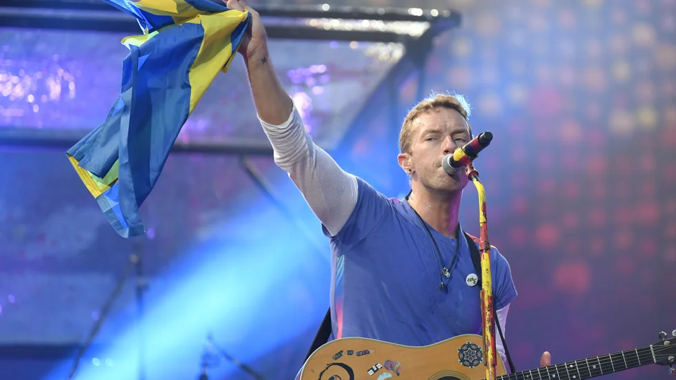 Chris Martin lyfter en svensk flagga under en spelning på Ullevi i Göteborg 2017. Arkivbild.