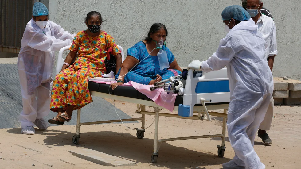 Vårdpersonal flyttar covidpatienter från ett sjukhus till ett annat i Ahmedabad i Indien.
