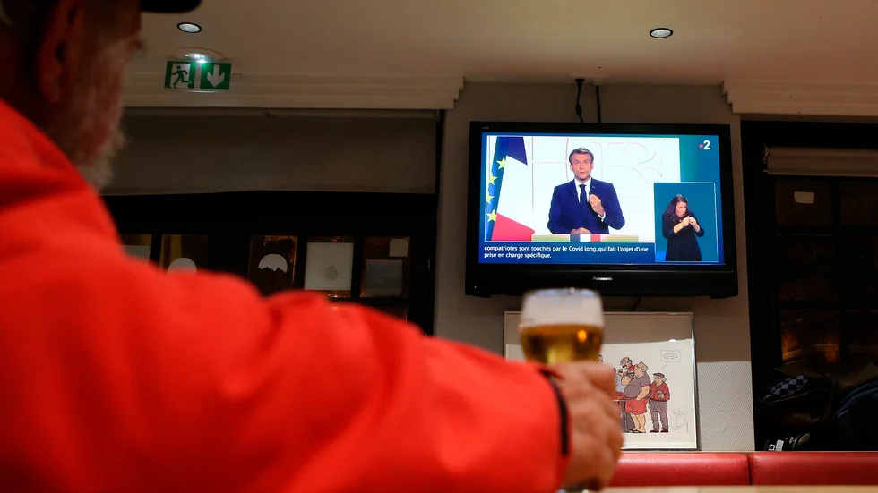 En man ser Macrons tv-tal på en bar i Baoynne i sydvästra Frankrike.