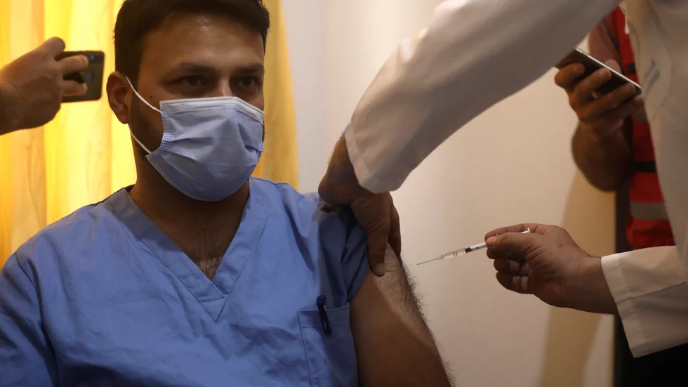 En sjuksköterska får en dos av Astra Zenecas covidvaccin vid sjukhuset Ibn Sina i staden Idlib i nordvästra Syrien på lördagen.