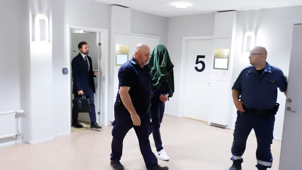 Den 38-årige misstänkte stockholmaren leddes in till rättegången av häktesvakter.