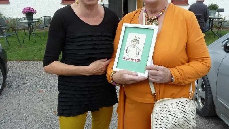Pigga "fruntimmer". Lilla Fruntimrets skapare Gunilla Dahlgren kåserade i Skärkinds kyrka på måndag och visar här upp den allra första teckningen av "fruntimret". Till vänster Lili Stenmark som var mäkta glad över dagens kåsör, som lockade cirka 200 åhörare.