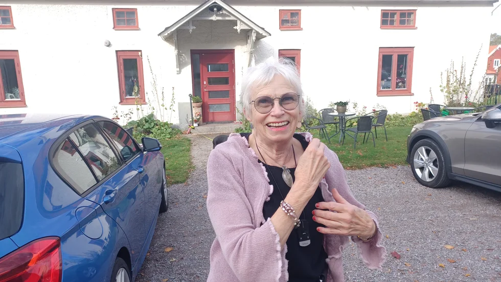 Lili Stenmark framför bostaden och galleriLi . Hon är på väg till mötet i församlingshemmet som finns på samma gårdsplan. Det är som högst 25 meter mellan kyrkan, galleriet och församlingshemmet. 