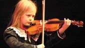Blott sjuåriga Julia Biegniewska kan redan showa och trollbinda en publik med sin musik och sina konster. Som här där hon vänt stråken upp och ned, men fortsätter att spela som inget har hänt...	
FOTO: ROBERT SVENSSON