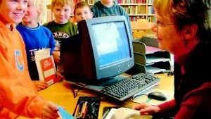Foto: MARGARETA LJUNGBLAD Monica Lind, filialföreståndare på biblioteken i Totebo och Hjorted, trivs väldigt bra med sitt jobb. Här är det Toteboelever som lånar böcker. Från vänster Tom Nilsson, Jim Högström, Adrian Ottosson, Rickard Dahlberg och Henrik Engström.