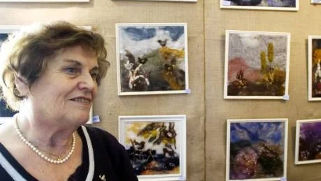 Ulla Hagbom är arrangör för Mårtenmässan som hon hoppas ska få fler intresserade av hantverk. Här står hon framför sin egen konst.