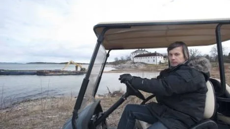 Utvecklingschefen Juha Lipsanen hos Mauritzbergs AB i en golfbil, framför den pågående muddringen för nya marinan och slottet i bakgrunden.