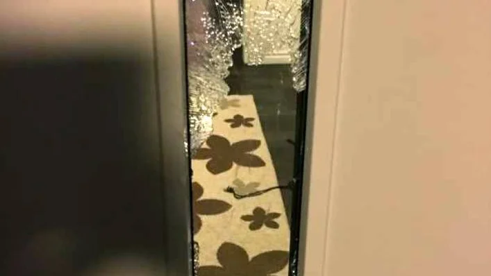Kvinnan som var hemma med sina två barn hotades av en yxman som slog sönder dörren.