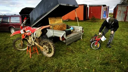 Motocrosspasset är slut och pappa Jens Adell packar ihop barnens saker. Både Emils crosshoj och Erikas cykel har sina givna platser i kärran. Bild: JOHANNA WALLIN