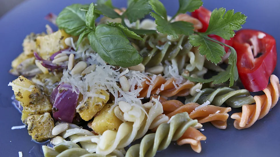 Pestogratinerad kålrot och rödlök med färgad pasta, ost och nötter blir en härlig vegetarisk varmrätt. Foto: Dan Strandqvist