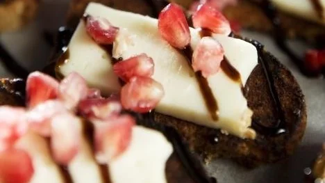 Pepparkakssnittar med taleggio och granatäpple.