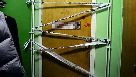 På dörren till lägenheten där knivdådet skedde under lördagsnatten syns ett blodigt handavtryck. Lägenheten är avspärrad för teknisk undersökning.