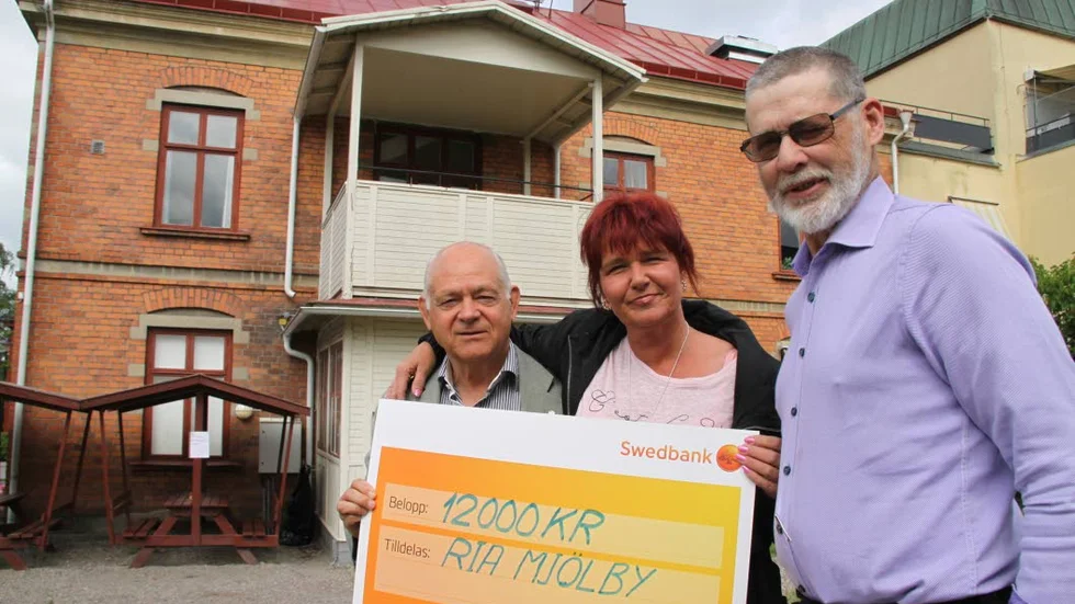 Bidrag. Hans Carlander och Anders Rockler i Mjölby Rotaryklubb flankerar Rias föreståndare Susanne Eriksson.