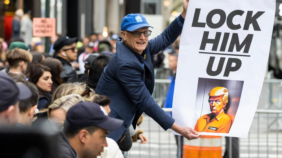 En demonstrant håller en skylt utanför Trump Tower i New York på måndagen.